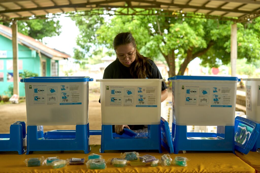 A woman sets up a WASH station
